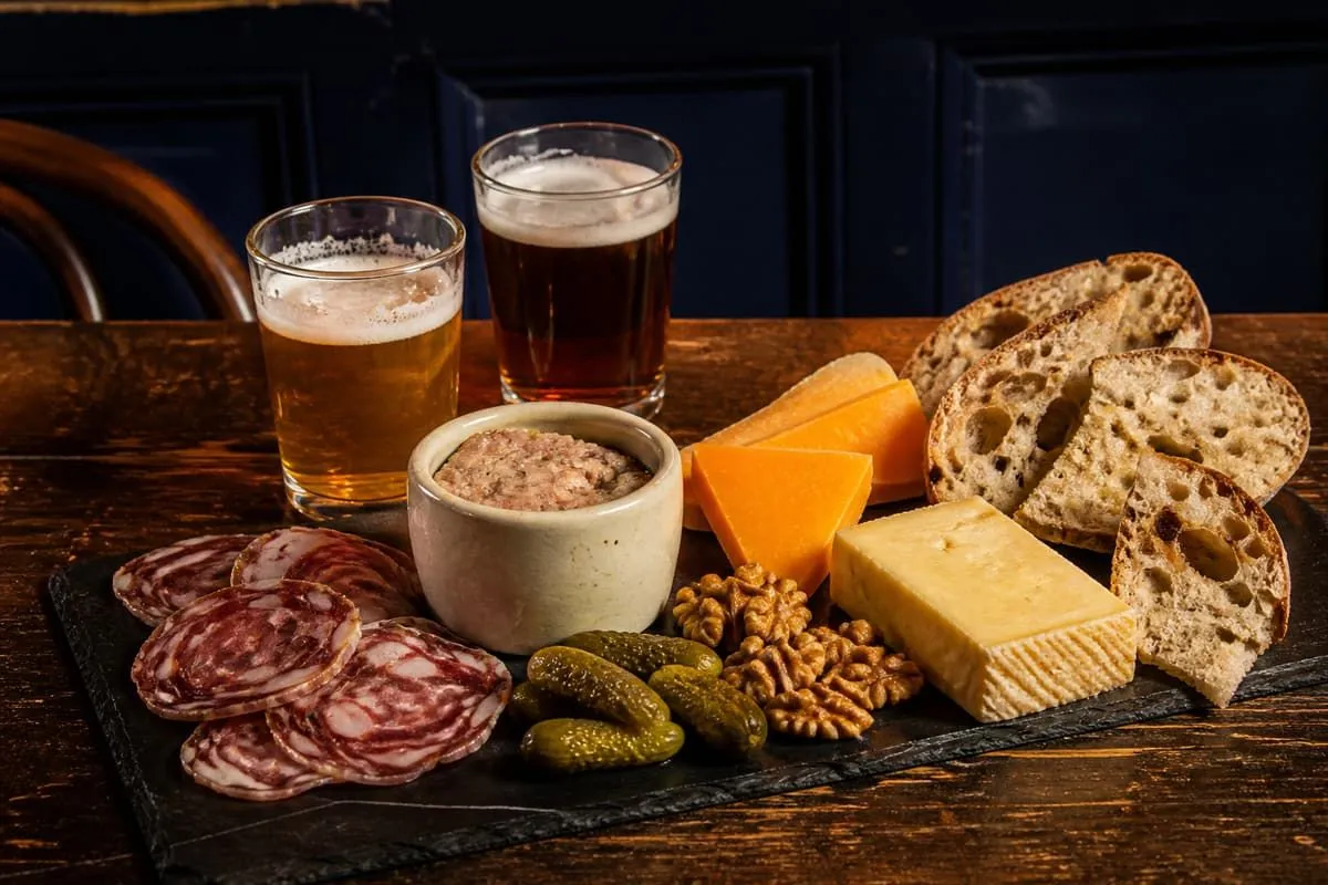 Planche à partager : charcuteries, pâté maison, Mimolette, Maroilles et pain au levain